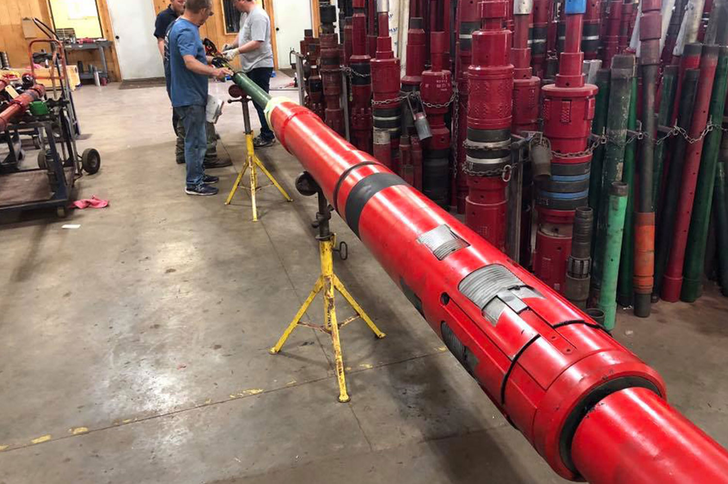 Group of Delta Oil Tools Employees Looking Over Liner Hanger