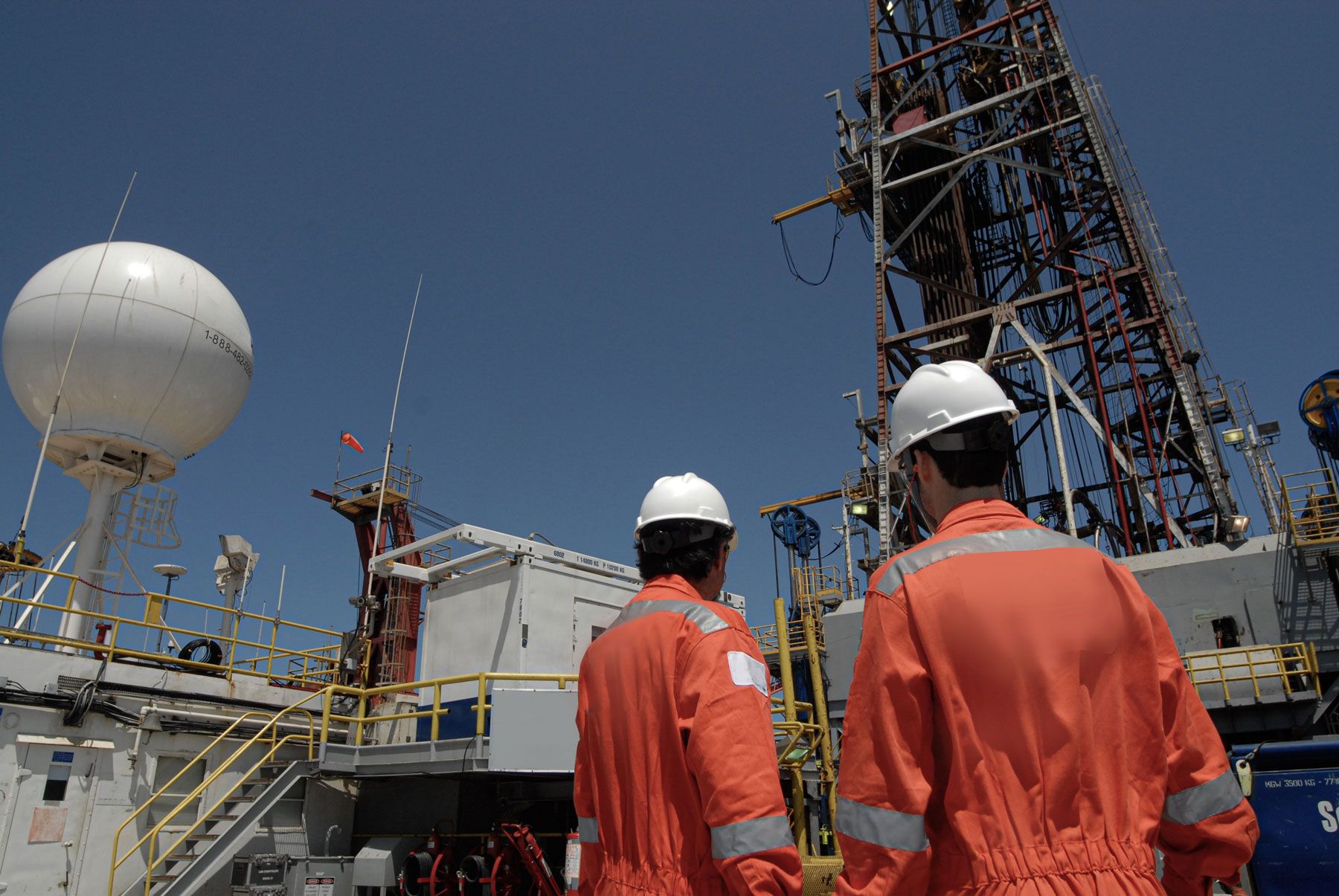 Two Workers Looking Over Oil Rig