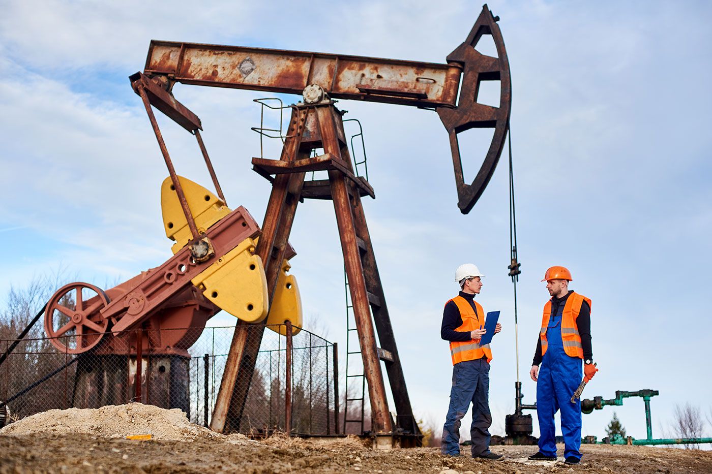 Two Employees Talking Near Oil Rig Machine
