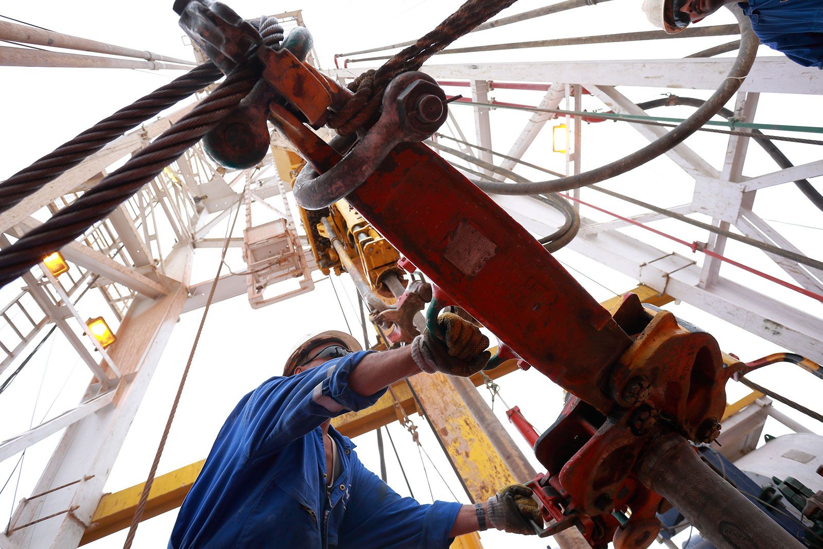 Worker Using Oil Rig Machine